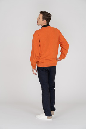 Junger mann im orangefarbenen pullover stehend