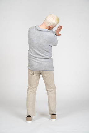 Rear view of man with hands crossed showing enough gesture