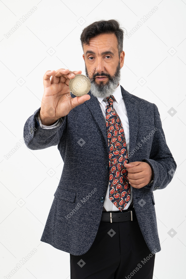 Mature man holding an iota coin