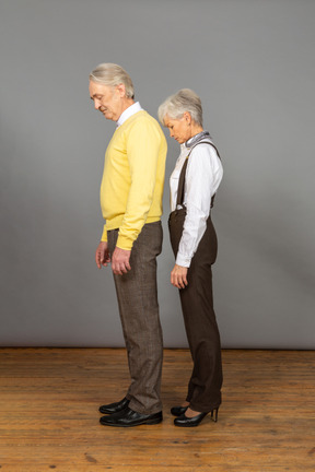 Middle-aged couple standing with their heads down