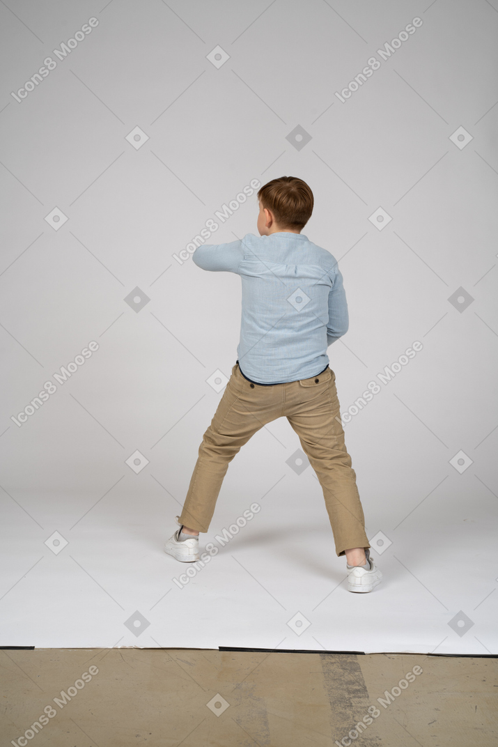 一个男孩站在蓝色衬衫的背影