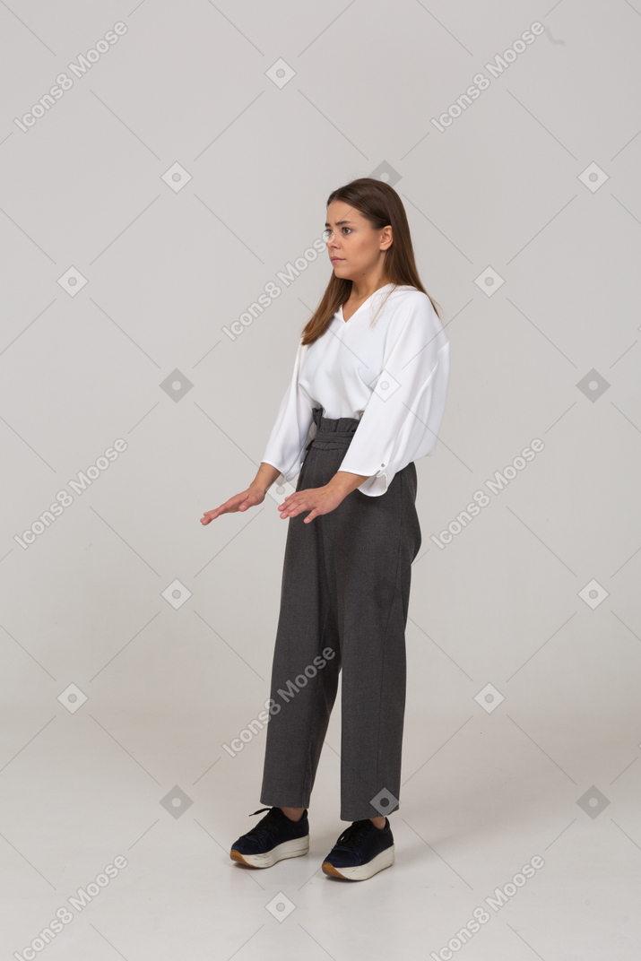 Вид в три четверти молодой леди в офисной одежде, поднимающей руки