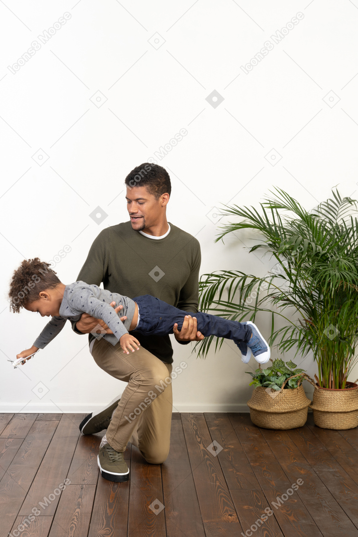 Good looking young man playing with a boy