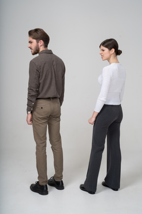 Three-quarter back view of a furious couple in office clothing clenching fists