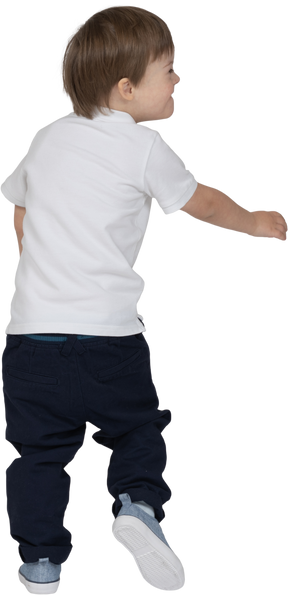 Back view of a boy stepping forward and smiling to the side