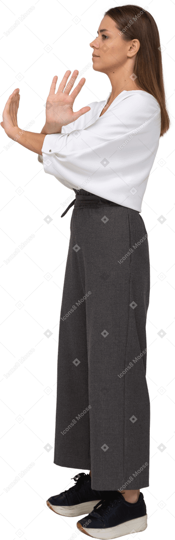 Side view of a young lady in office clothing crossing arms
