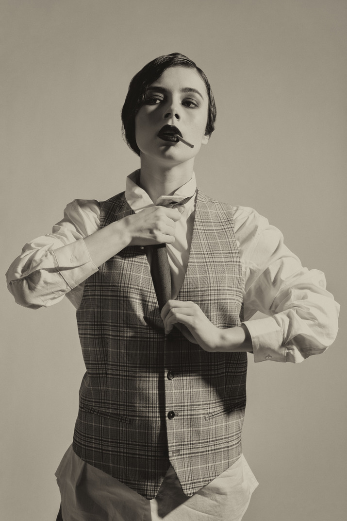Old-fashioned woman adjusting a tie