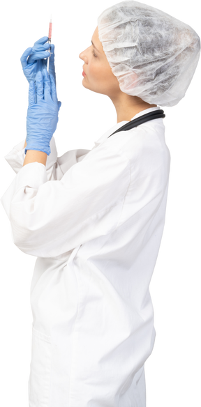 Vista lateral de una joven doctora sosteniendo una jeringa
