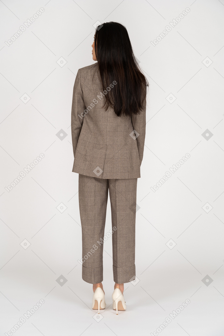 Back view of a young lady in brown business suit looking aside