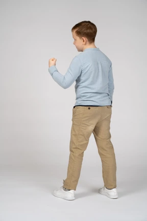 Rear view of a boy showing fist