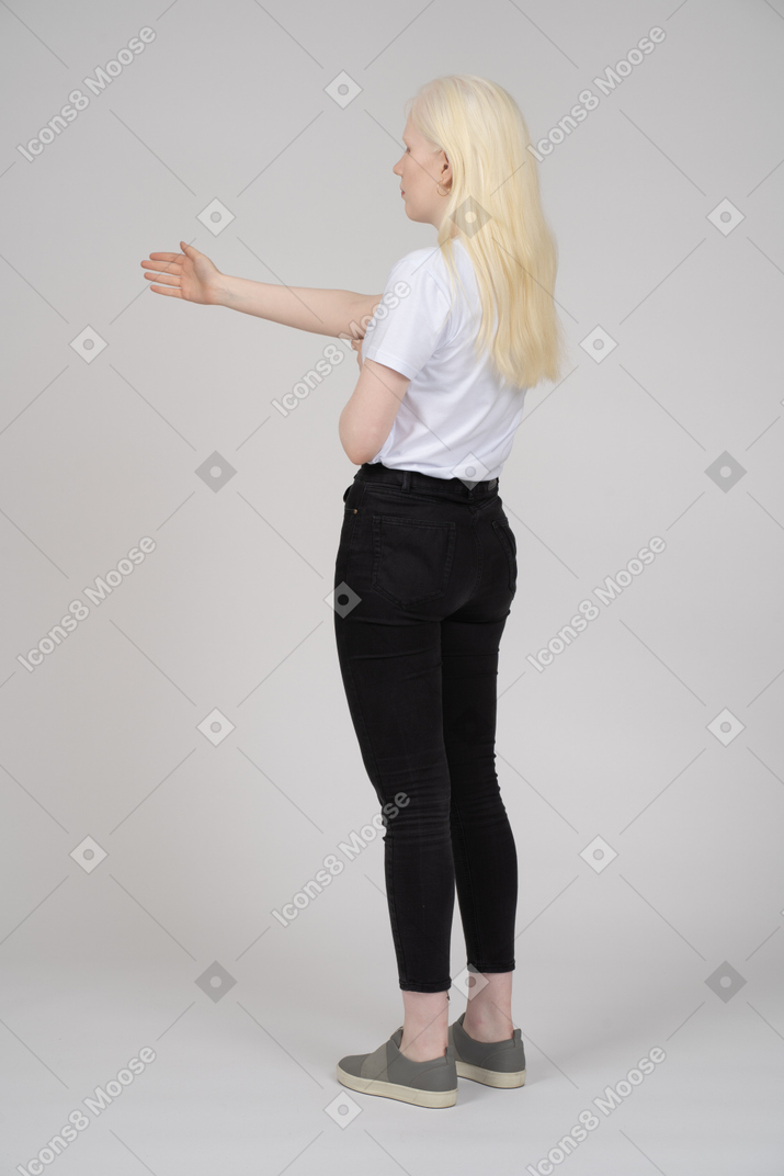 Vista traseira de uma mulher de cabelos compridos com o braço estendido