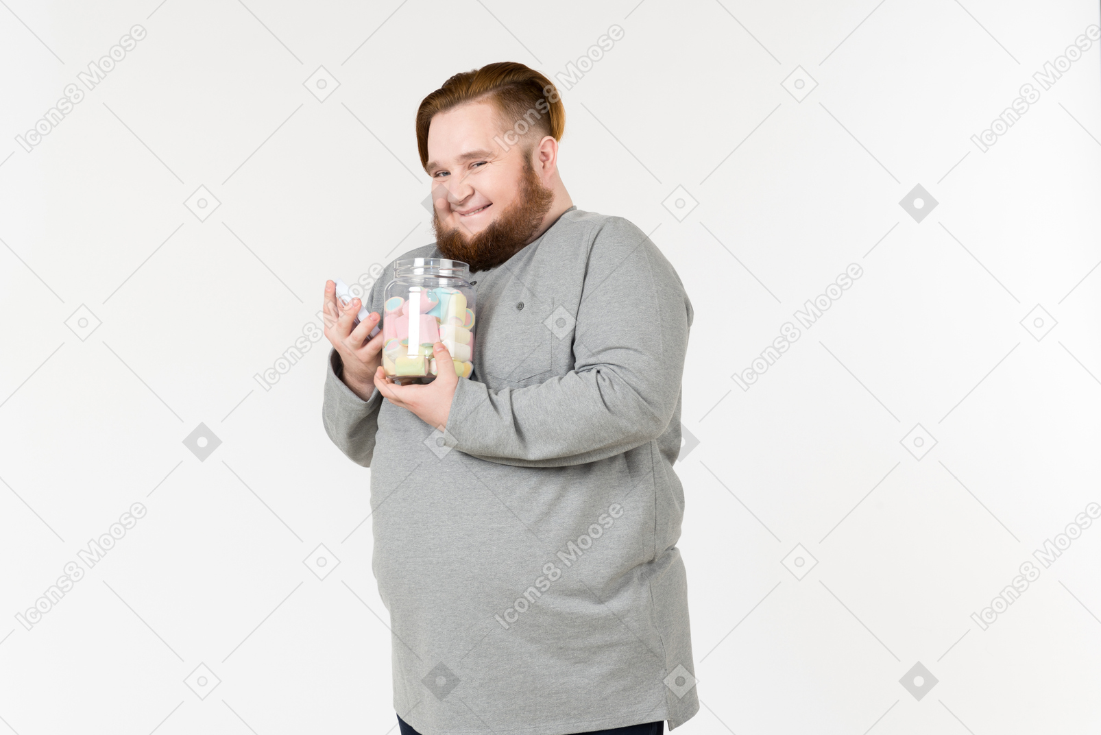 Laughing big bearded man holding jar of marshmallows