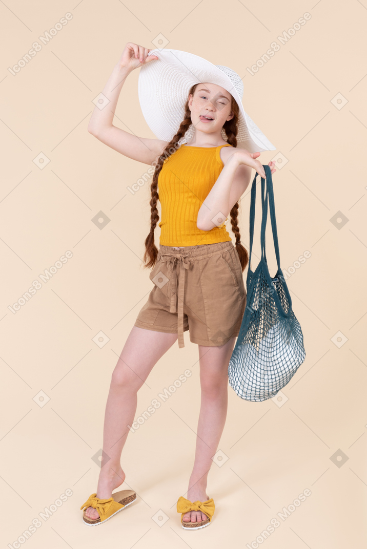 Teenage girl in white hat winking and holding avoska