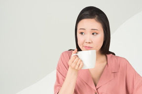 A woman in a pink shirt is holding a cup