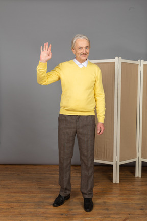 Vista frontal de un amable anciano saludando