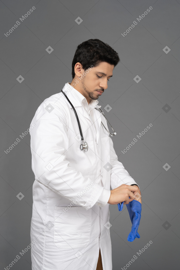 Doctor takes off his blue gloves