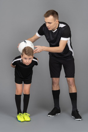 De cuerpo entero de un joven entrenando a un niño