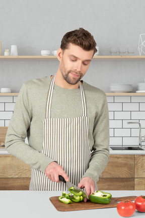 A man is chopping vegetables in a kitchen