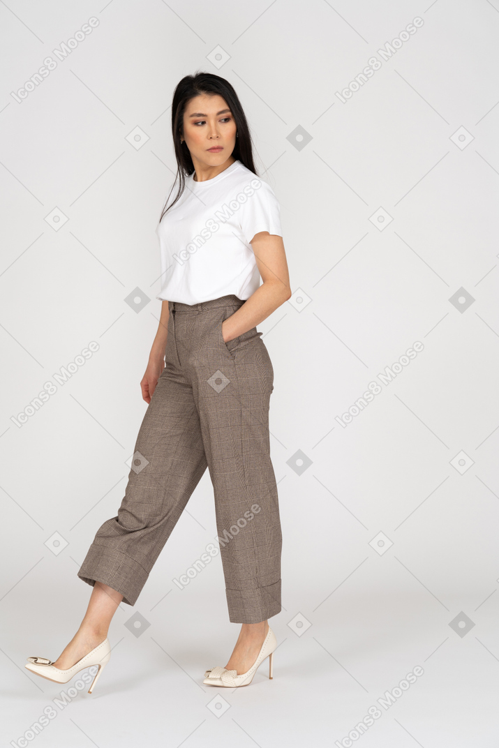 Vista de tres cuartos de una joven dama caminando en calzones y camiseta mirando a un lado