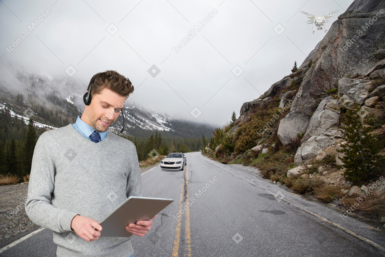 A man wearing headphones is looking at a tablet