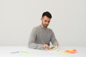 Beau jeune homme fait de la broderie