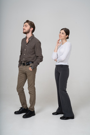 Vue de trois quarts d'un homme en vêtements décontractés mettant les mains dans les poches et une jeune femme heureuse