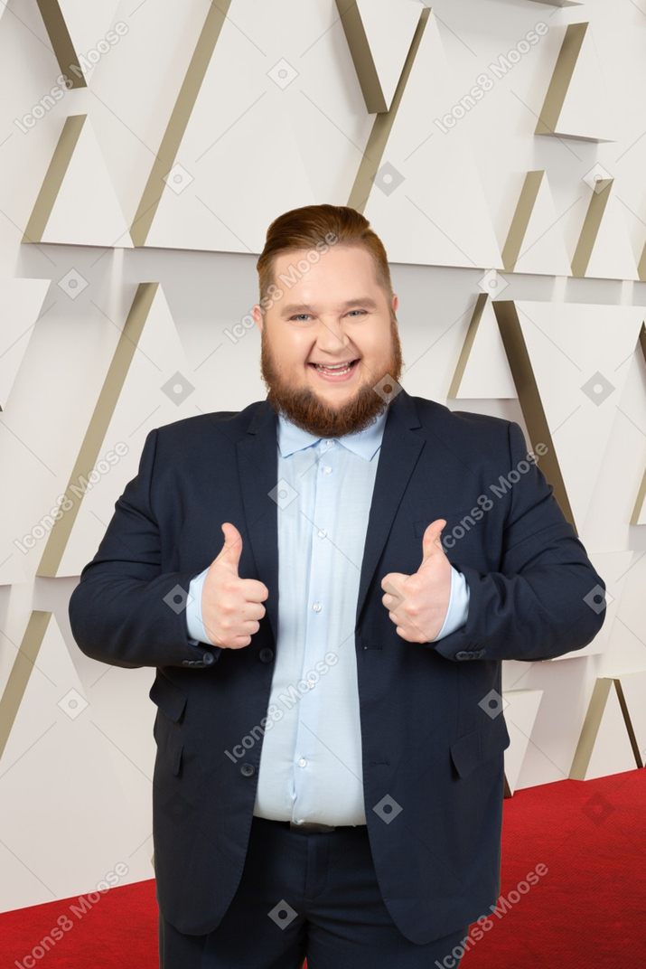 A bearded man giving thumbs up on the oscars red carpet