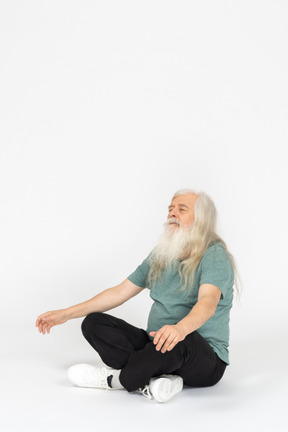 Three-quarter view of old man meditating