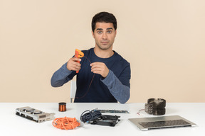 A young man in casual blue clothes working with computer details