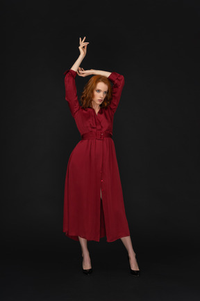 Giovane donna in rosso con le braccia alzate