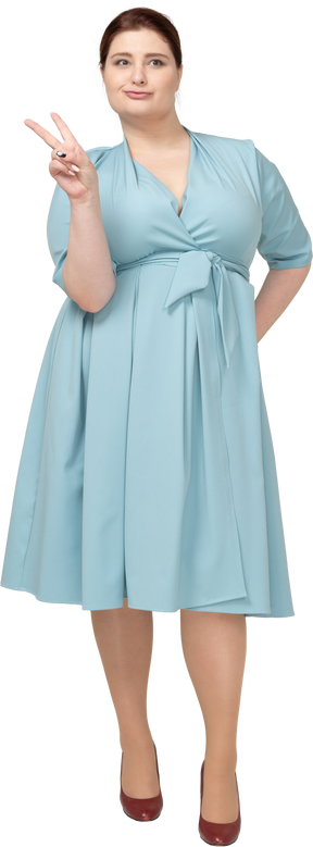 Вид спереди женщины в синем платье, показывающей жест v