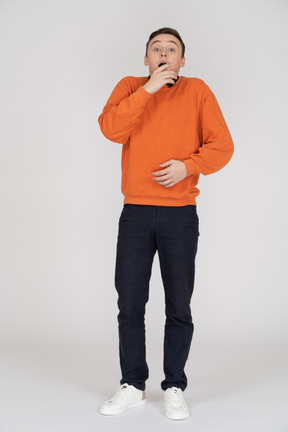 Young man in orange sweatshirt standing