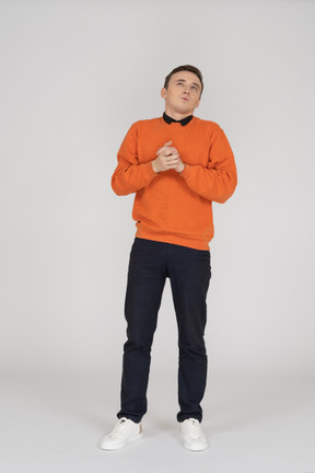 Young man in orange sweatshirt standing