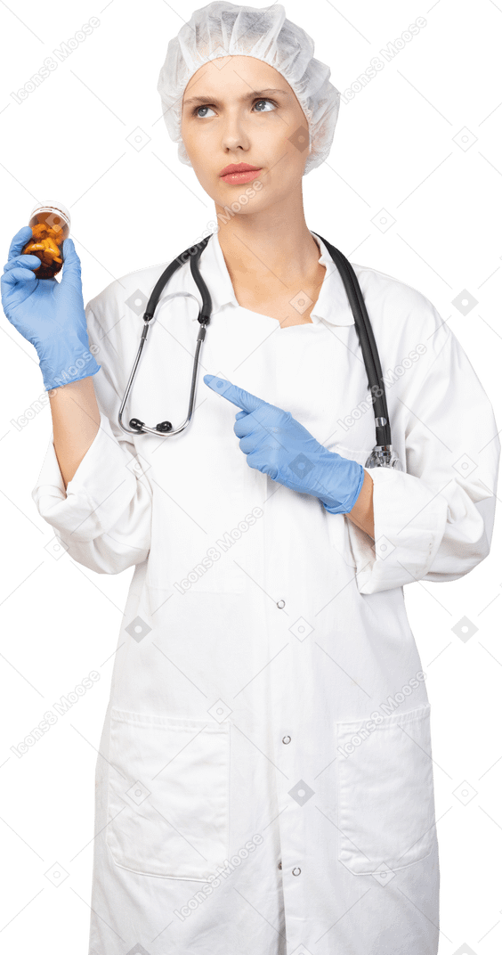 Vista frontal de una joven doctora perpleja sosteniendo un frasco de pastillas