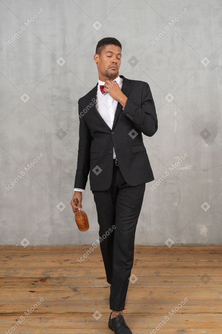Young man walking and adjusting his bowtie