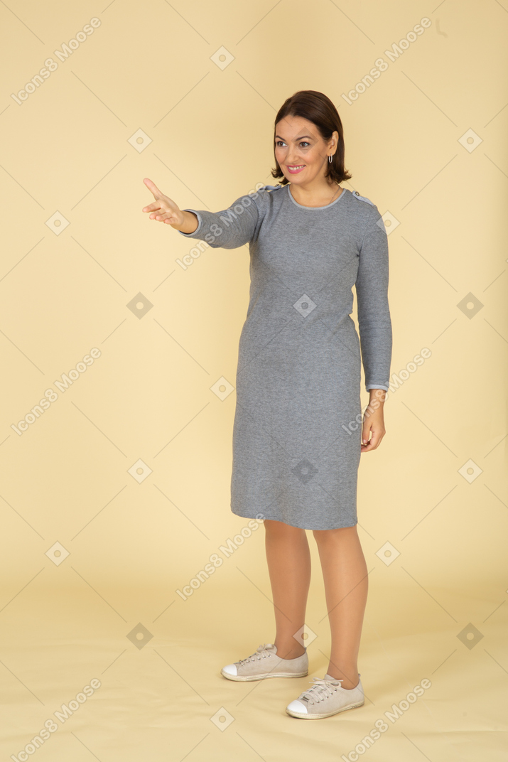 身振りで示す灰色のドレスを着た女性の正面図