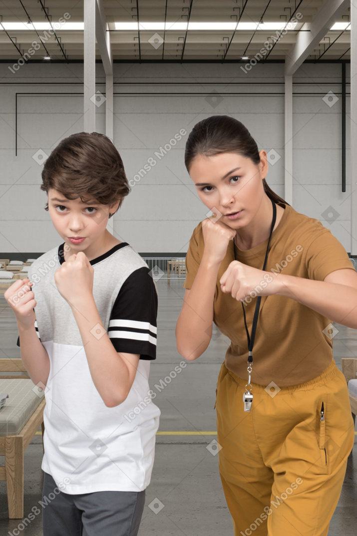 Woman trainer teaches boy boxing