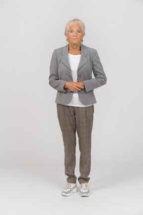 Vista frontale di una vecchia donna in giacca e cravatta che guarda la telecamera
