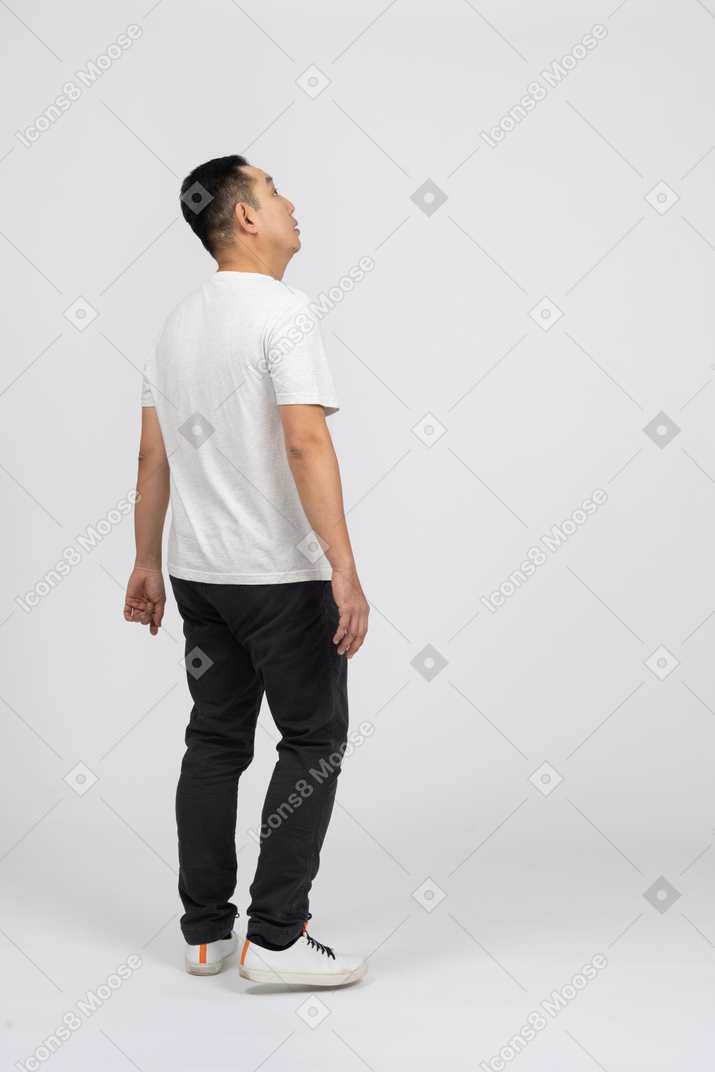 Vista laterale di un uomo in abiti casual che guarda in alto