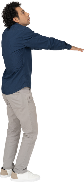 Vista lateral de um homem com roupas casuais em pé com os braços estendidos