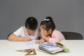 Brother and sister helping each other do homework