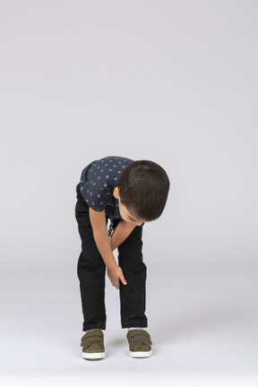 Front view of a boy bending down