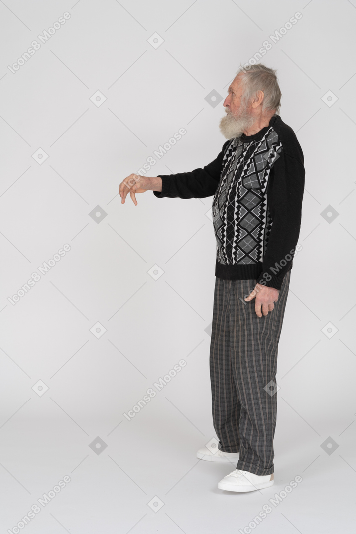 Side view of an old man holding out his hand