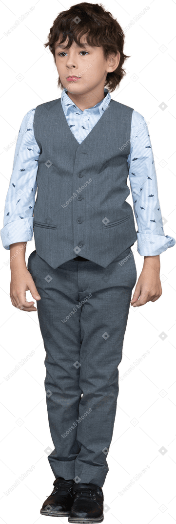 Vista frontal de un niño en traje gris parado