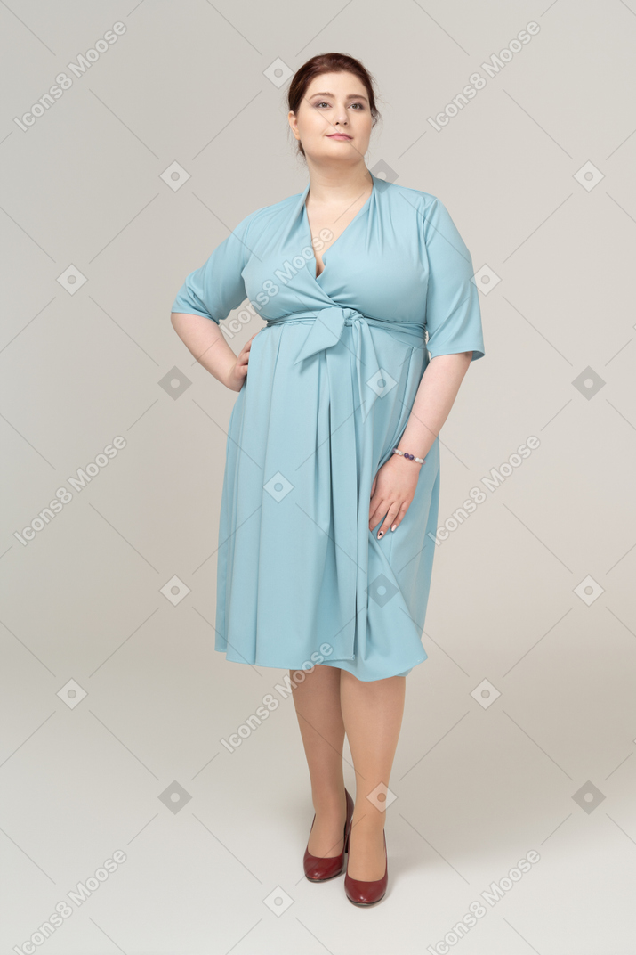 Vista frontal, de, un, mujer, en, vestido azul, posar, con, entregue cadera