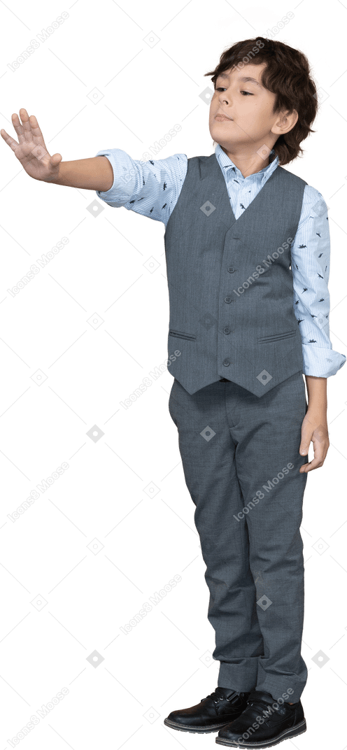 Vue de face d'un garçon en costume gris montrant un geste d'arrêt
