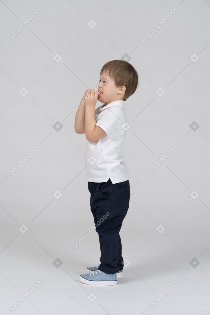 彼の指を吸う少年の側面図