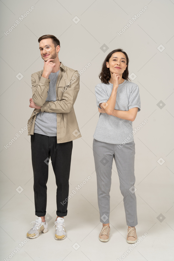 Young couple smiling with hand on chin