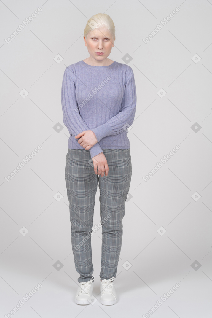 Calm young woman standing with folded arms