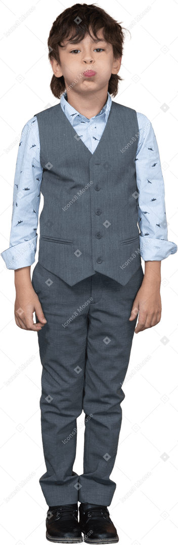 Vista frontal de un niño en traje gris hinchando las mejillas